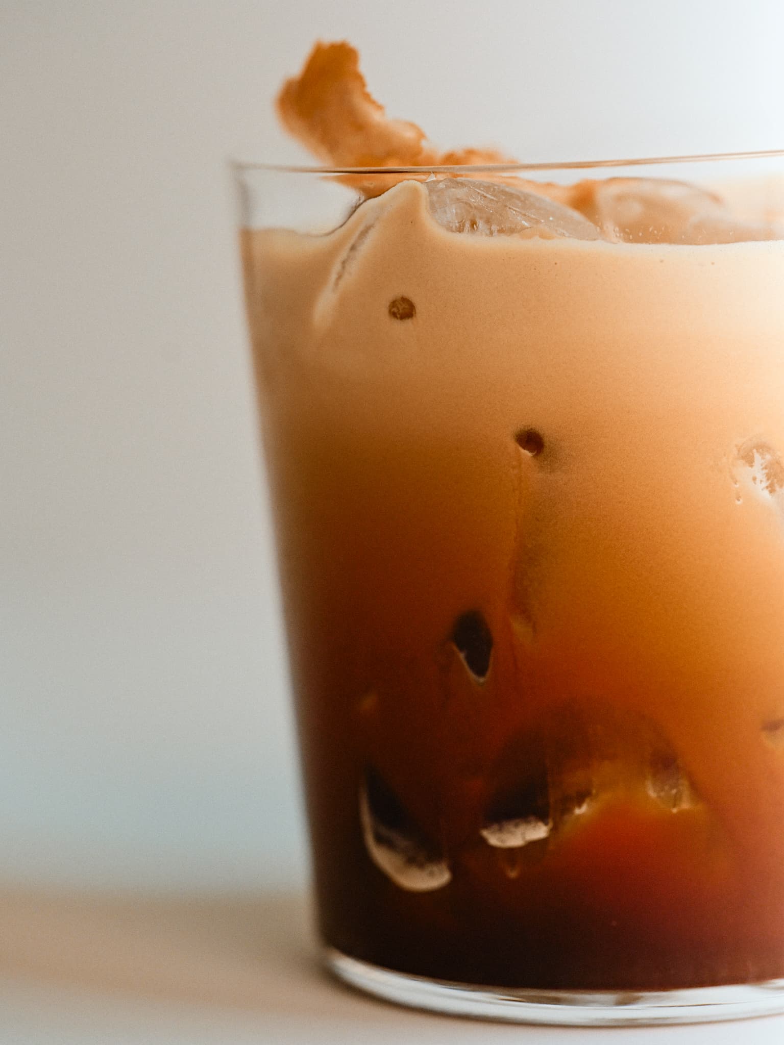 Aerocano iced coffee with foam in a clear glass