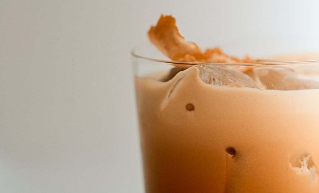 Iced creamy drink garnished with dried citrus peel